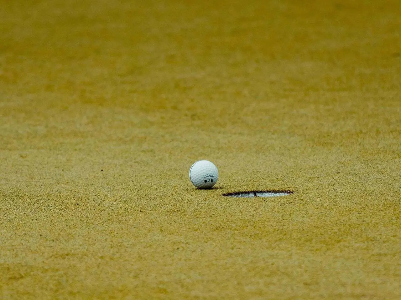 Golfbold ved hullet på greenen